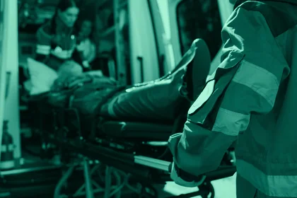 Equipo de paramédicos subiendo una camilla a la ambulancia